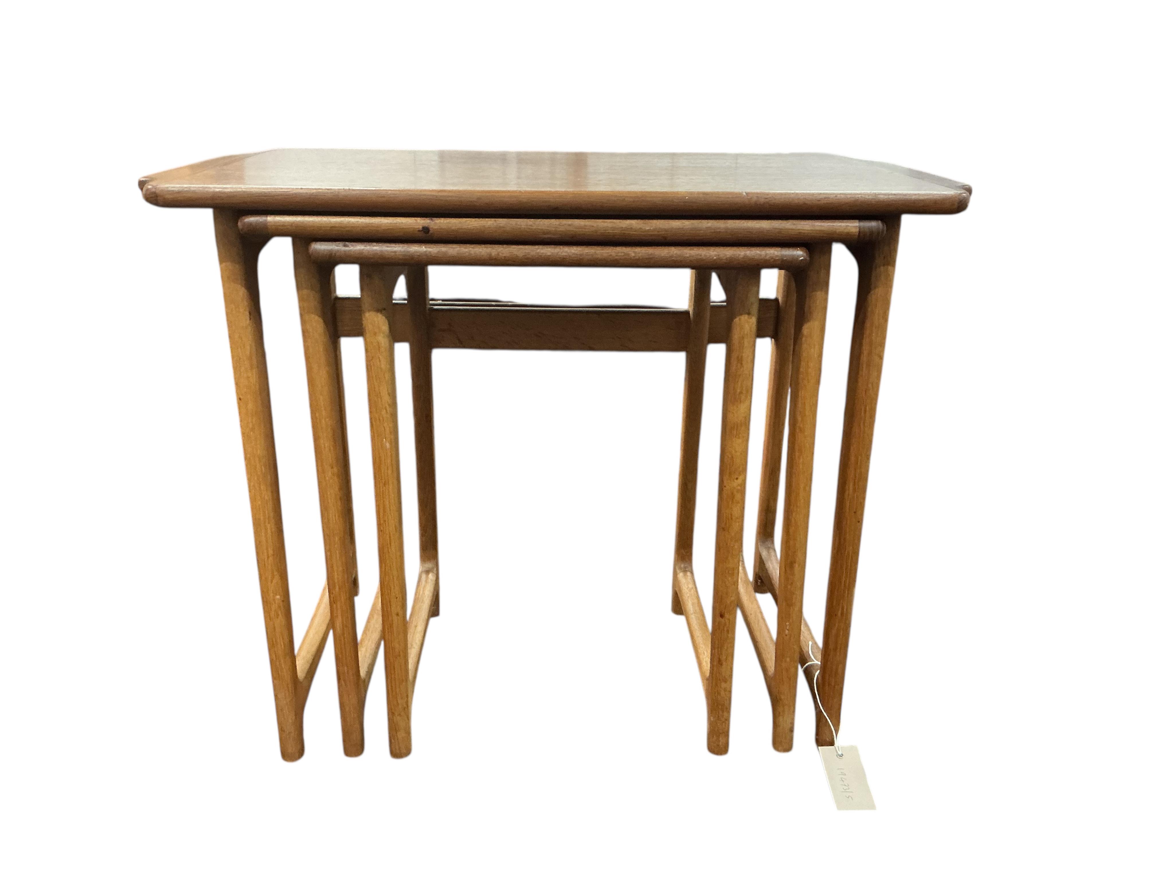 A nest of three mid century teak rectangular tables, width 65cm, depth 38cm, height 51cm